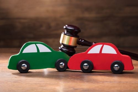 two toy cars and a gavel