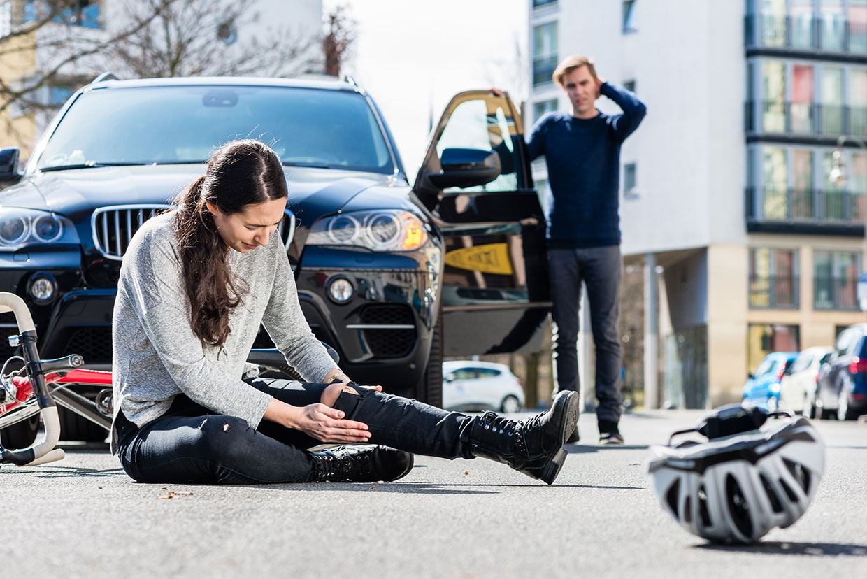 woman on the road after being hit off of her bike